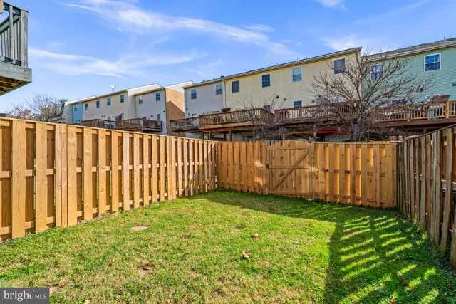 a view of a back yard with an wooden fence