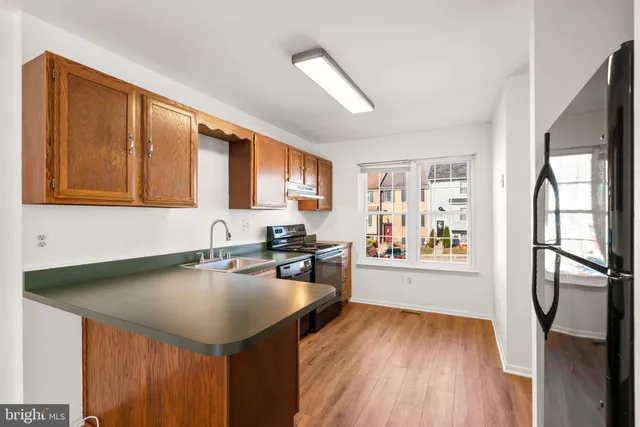 a kitchen with stainless steel appliances granite countertop a sink refrigerator stove and microwave