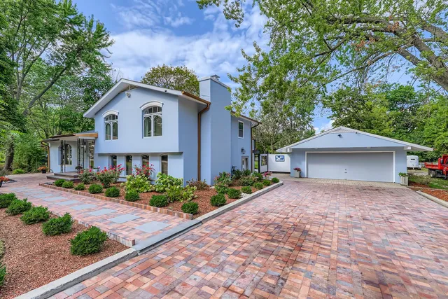 a view of a house with a yard and large tree