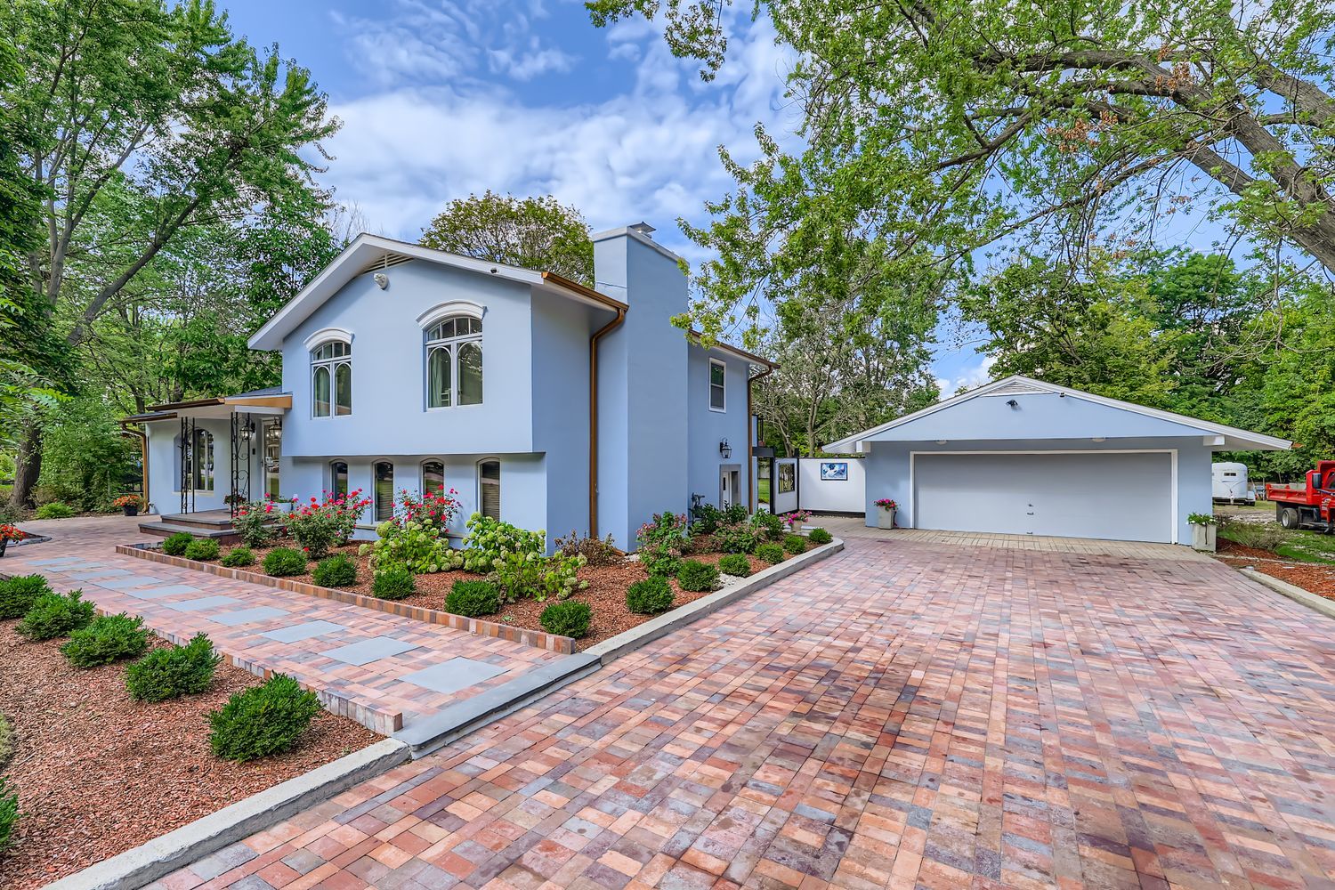 a view of a house with a yard and large tree