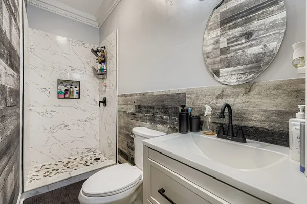 a bathroom with a sink a toilet and shower