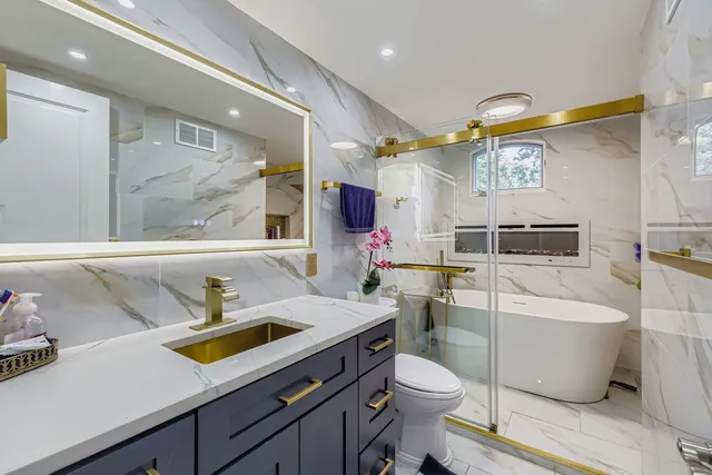 a bathroom with a sink a toilet and shower