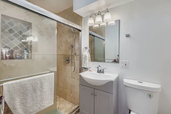 a bathroom with a sink a toilet and shower