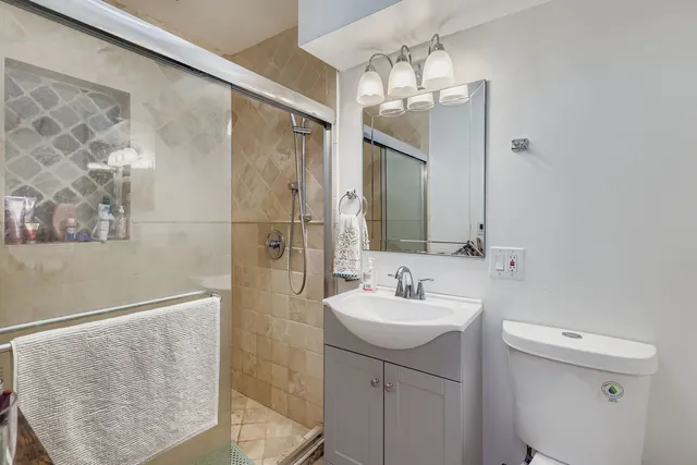 a bathroom with a sink a toilet and shower