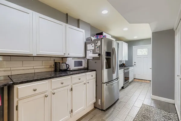 a kitchen with stainless steel appliances a refrigerator a sink and cabinets