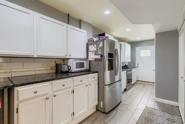 a kitchen with stainless steel appliances a refrigerator a sink and cabinets