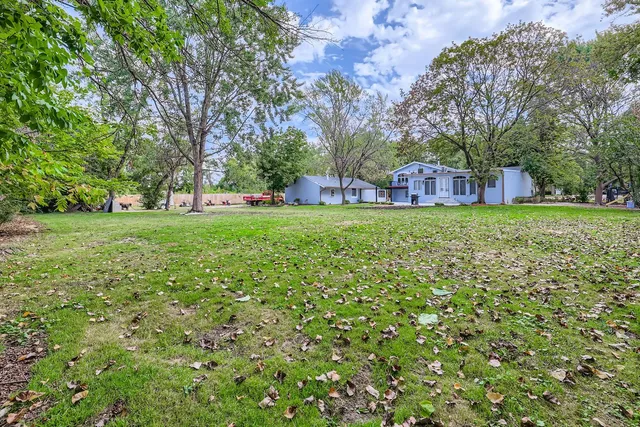 a backyard of a house with lots of green space and fountain