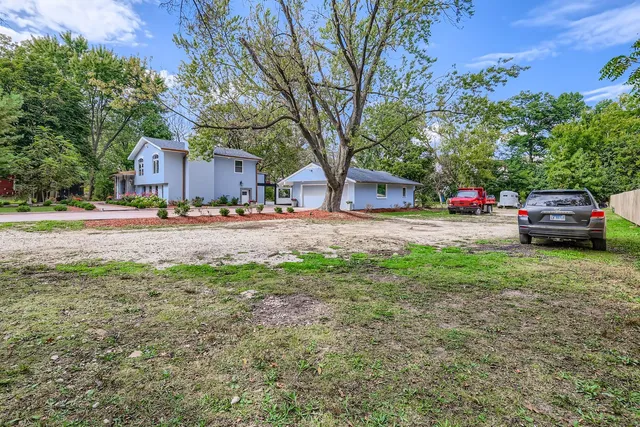 a front view of a house with a yard and trees