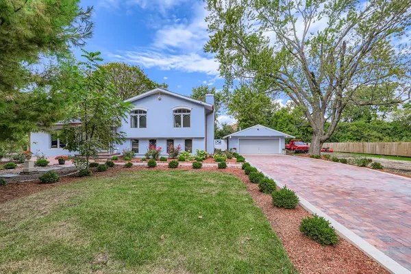 a view of a house with backyard and a tree
