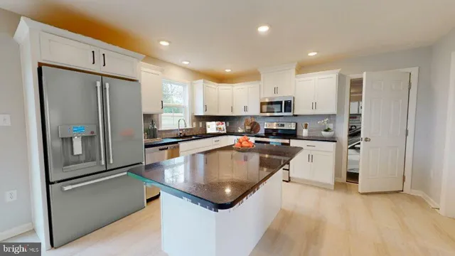 a living room with furniture a flat screen tv and kitchen view