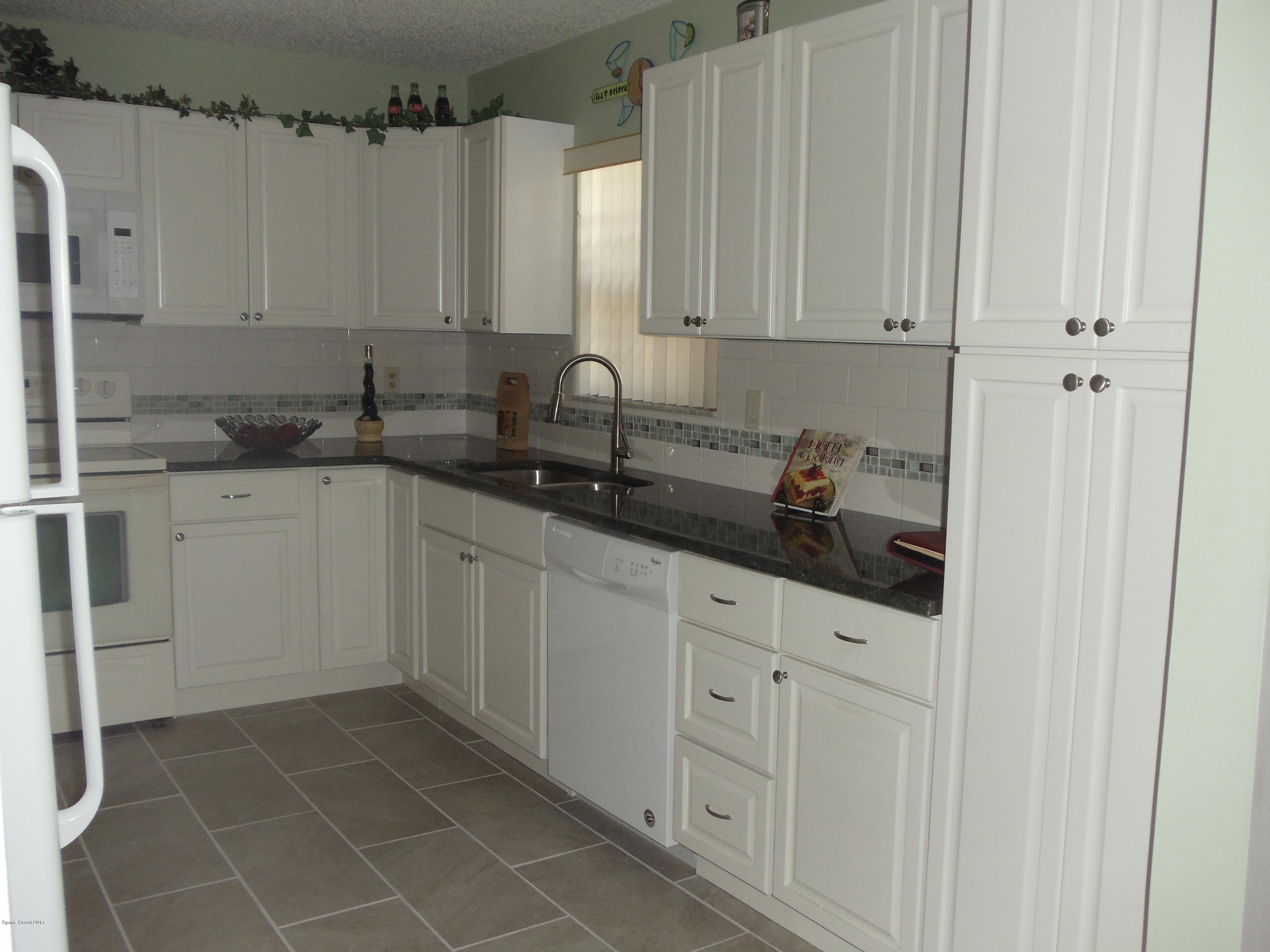 271 Trilby Road Southwest Palm Bay, FL 32908 - Photo 12 of 27 a kitchen with stainless steel appliances a sink and cabinets