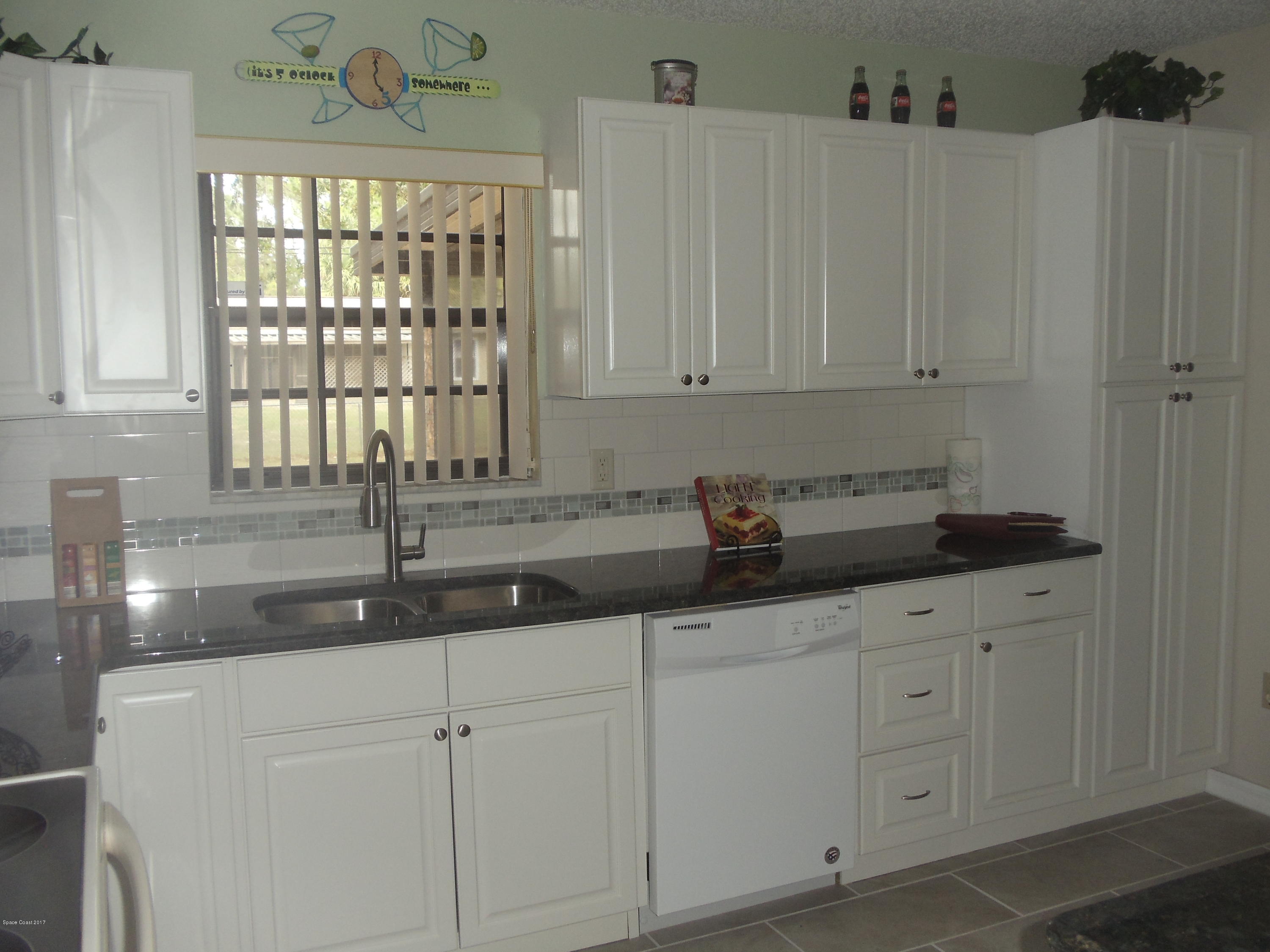 271 Trilby Road Southwest Palm Bay, FL 32908 - Photo 13 of 27 a kitchen with granite countertop white cabinets and sink