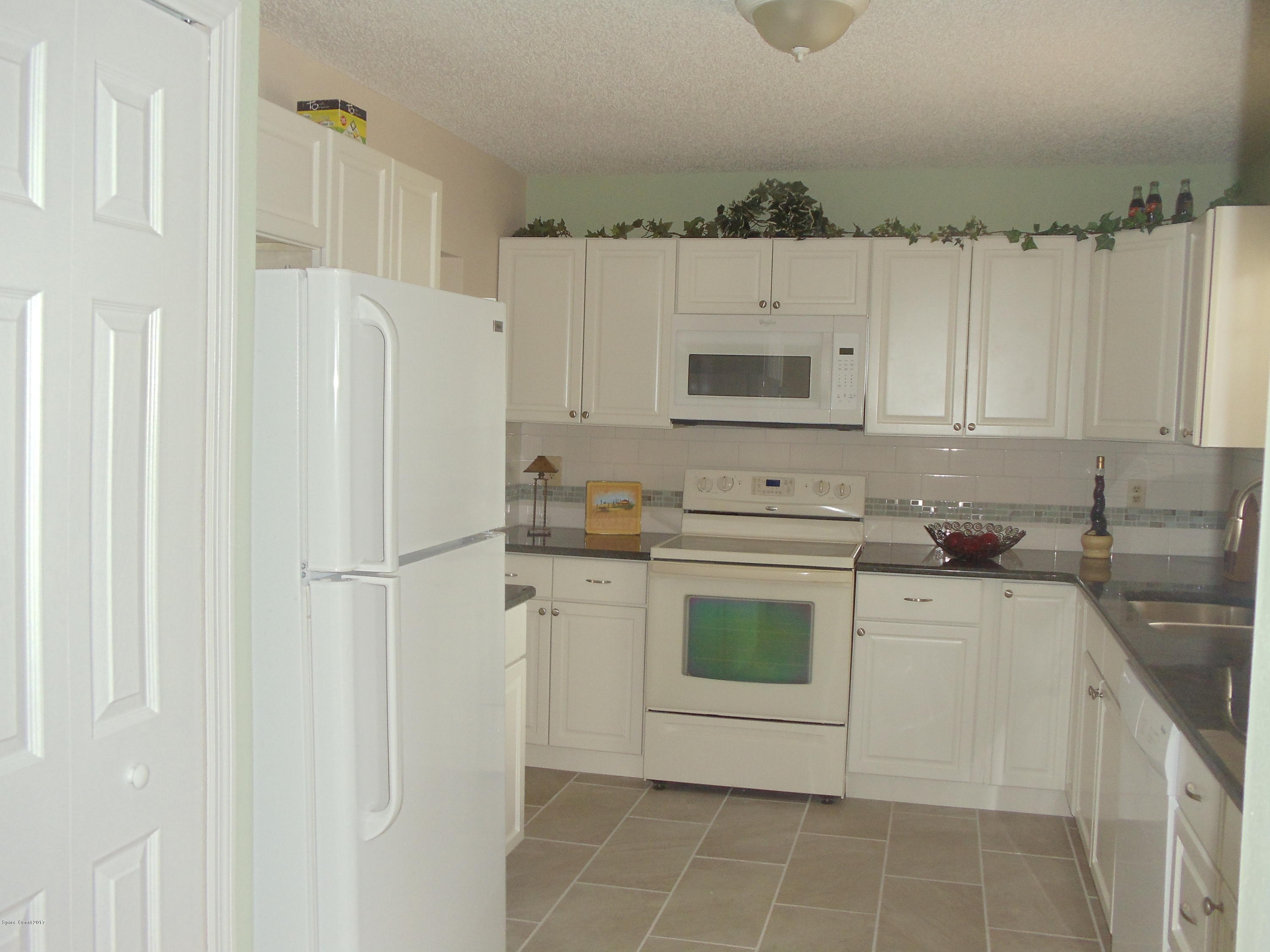 271 Trilby Road Southwest Palm Bay, FL 32908 - Photo 14 of 27 a kitchen with stainless steel appliances a white cabinet and a refrigerator