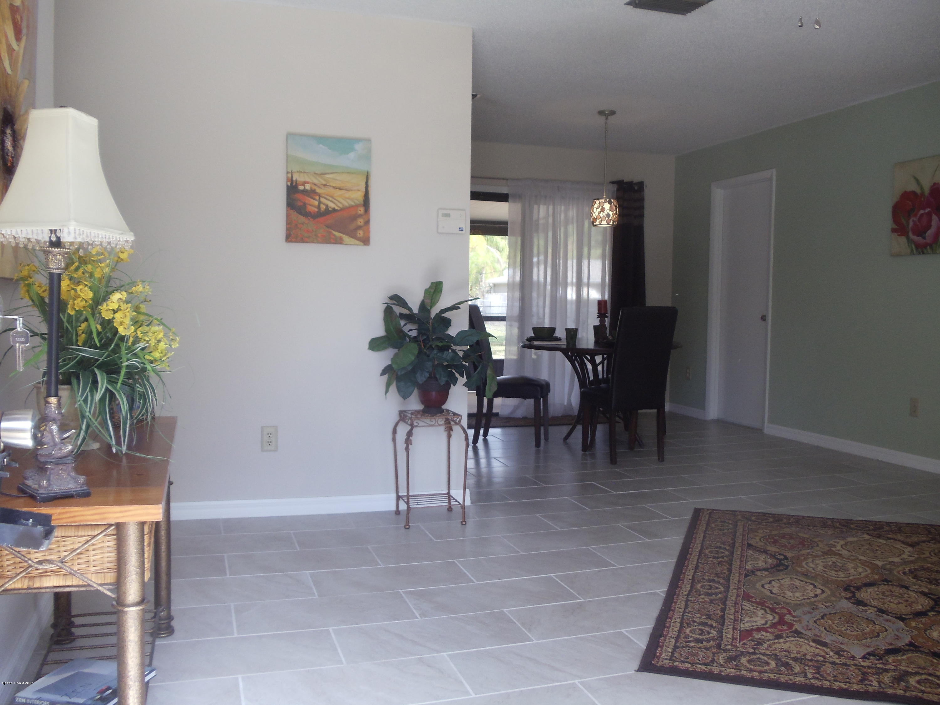 271 Trilby Road Southwest Palm Bay, FL 32908 - Photo 8 of 27 a view of a dining room with furniture and a potted plant