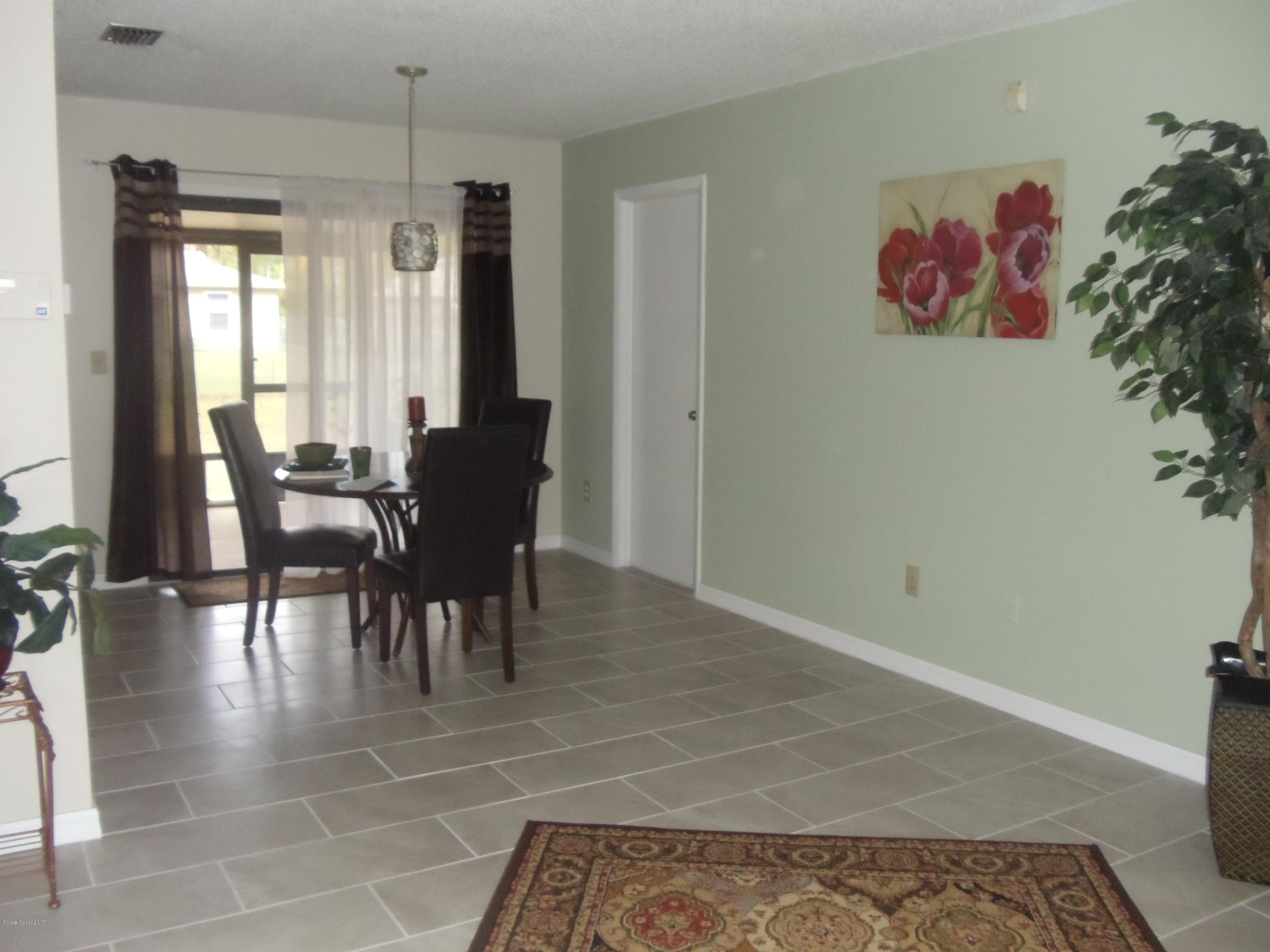 271 Trilby Road Southwest Palm Bay, FL 32908 - Photo 9 of 27 a view of a dining room with furniture and wooden floor