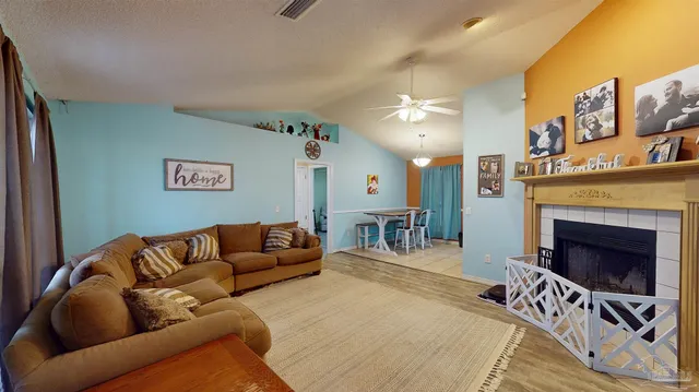 a living room with furniture a fireplace and a flat screen tv