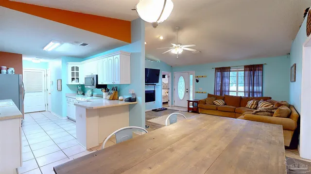 a kitchen with stainless steel appliances a refrigerator a sink a stove and white cabinets