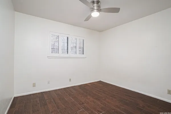 an empty room with a window and wooden floor