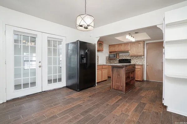 a kitchen with stainless steel appliances kitchen island granite countertop a refrigerator and a sink