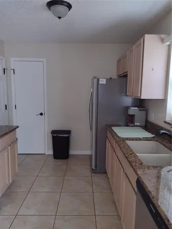 a kitchen with stainless steel appliances granite countertop a sink a stove and a refrigerator