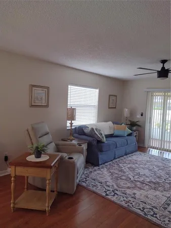 a living room with couch dresser and wooden floor