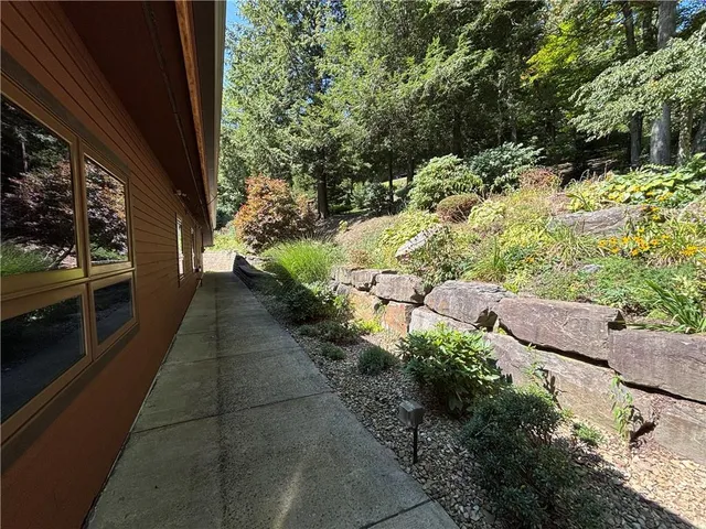 a view of a house with backyard and trees