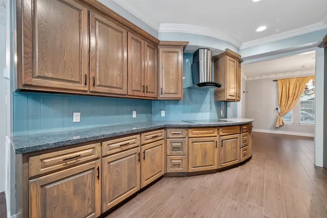a kitchen with stainless steel appliances granite countertop a sink and cabinets with wooden floors