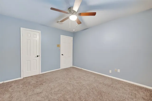 an empty room with closet and fan
