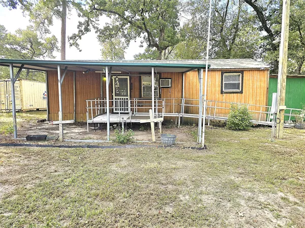 a view of a house with backyard and sitting area