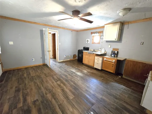 a kitchen with granite countertop a stove and a wooden floors