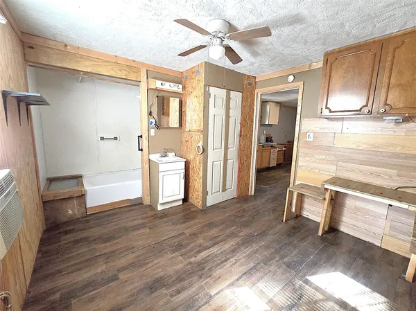 a living room with stainless steel appliances furniture and a kitchen view