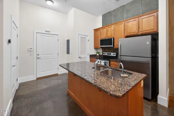 a kitchen with stainless steel appliances granite countertop a sink refrigerator and microwave