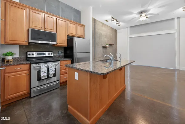a kitchen with stainless steel appliances granite countertop a stove a sink and a refrigerator