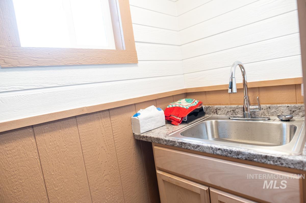 736 East Main Street Weiser, ID 83672 - Photo 11 of 33 Kitchen featuring wood walls, light countertops, and light wood finish cabinetry