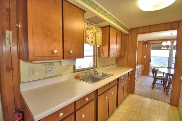a kitchen with a refrigerator a sink and dishwasher with a large window