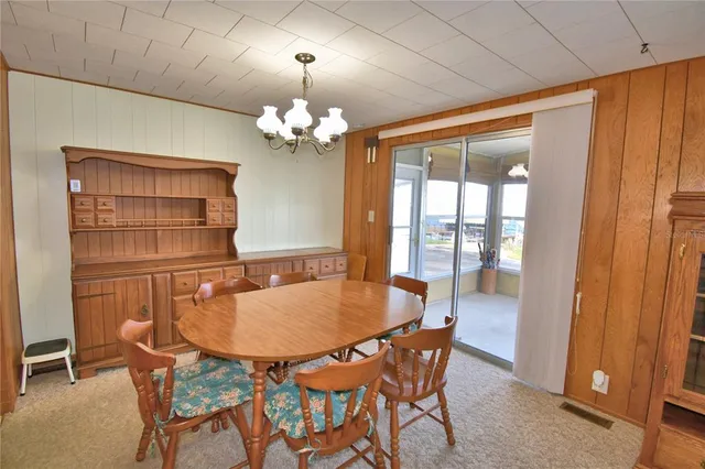 a living room with dining table furniture and a chandelier