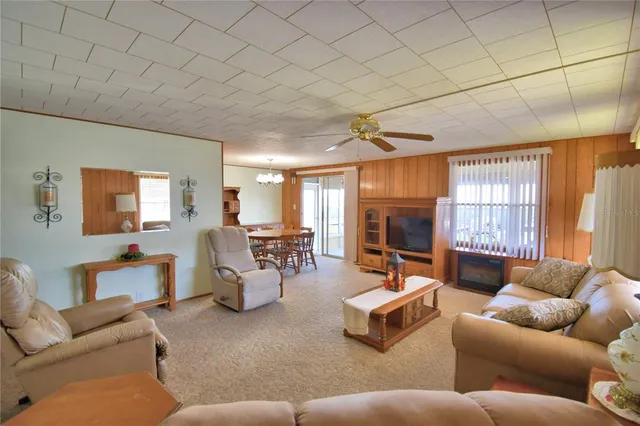 a view of an empty room with a floor to ceiling window next to a yard
