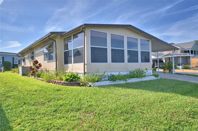 a front view of a house with a yard and potted plants