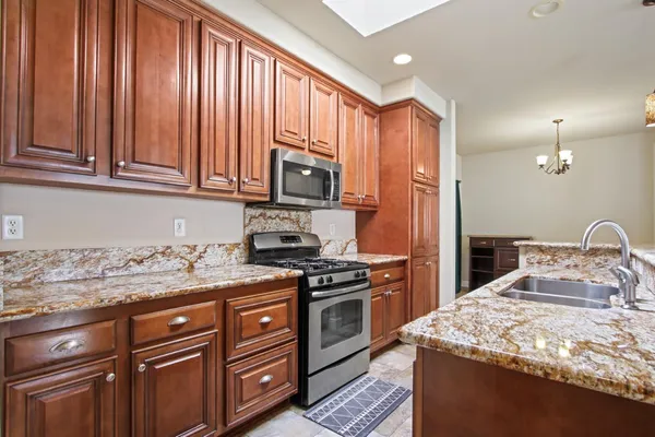 a kitchen with granite countertop wooden cabinets and stainless steel appliances