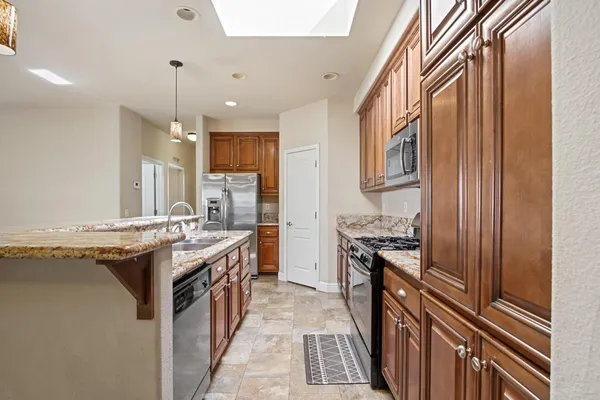 a kitchen with stainless steel appliances granite countertop a stove and a refrigerator