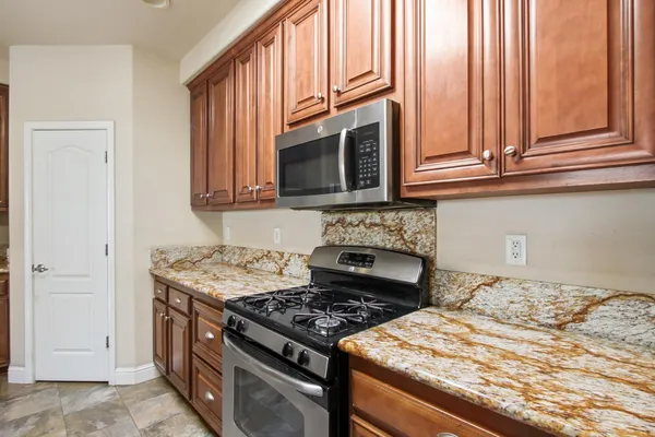 a kitchen with granite countertop a stove and a microwave