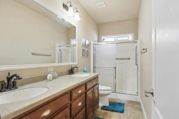a bathroom with a sink a toilet and a large mirror