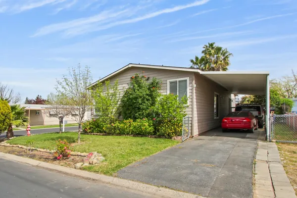 a front view of a house with a yard and potted plants