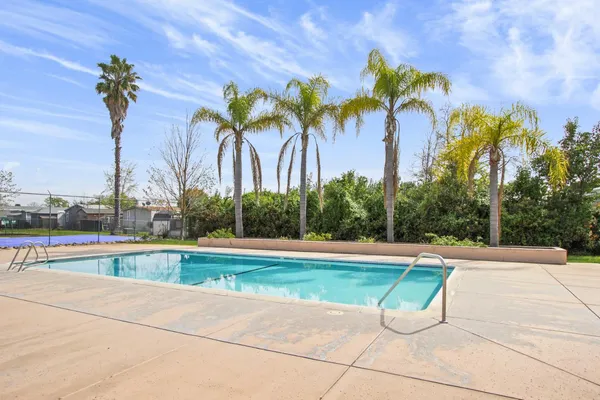 a view of backyard with swimming pool and outdoor seating