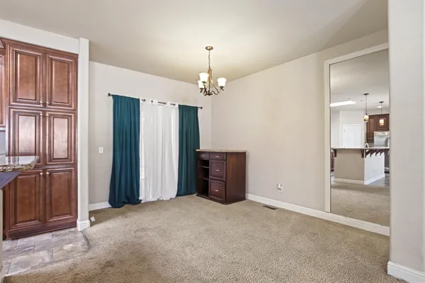 an empty room with kitchen and windows