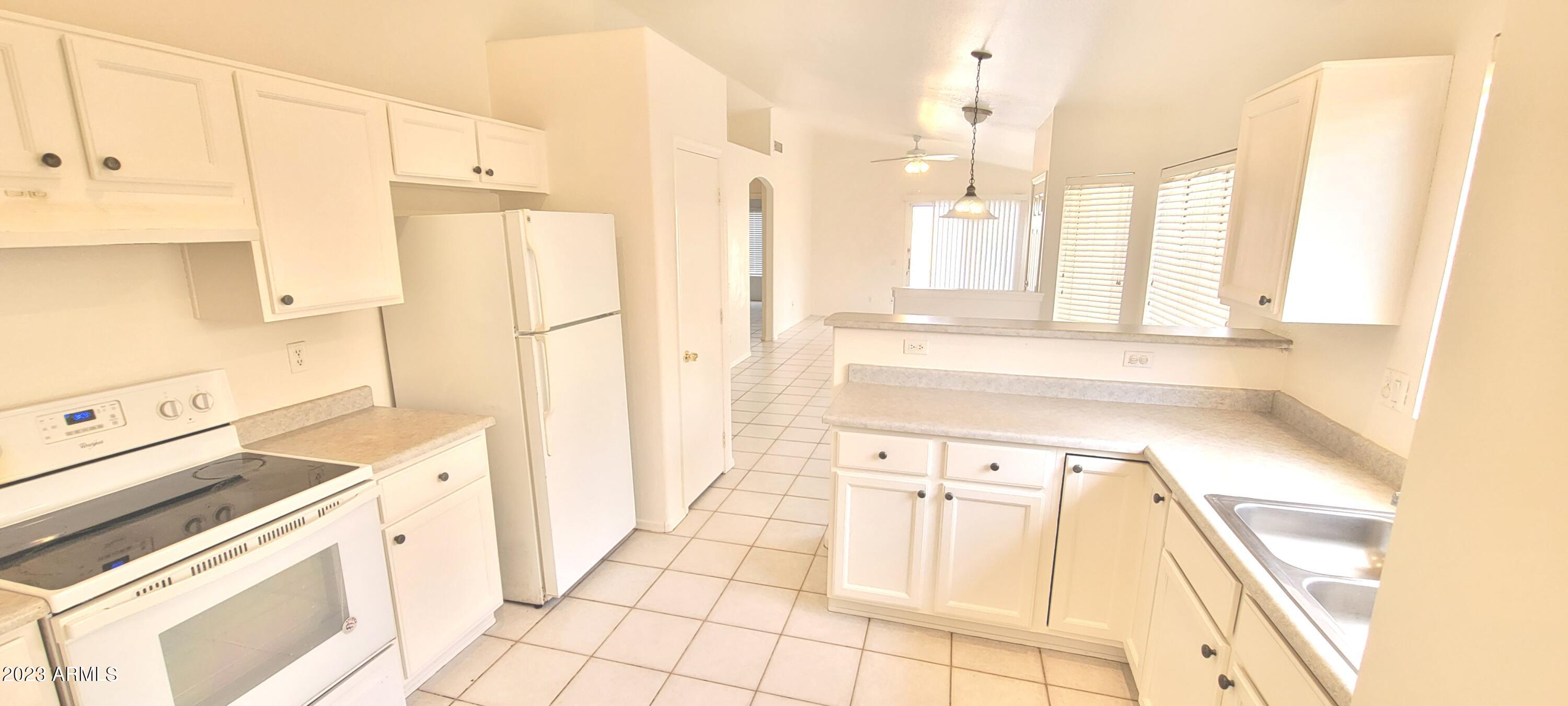 1202 North Bogle Avenue Chandler, AZ 85225 - Photo 6 of 16 a kitchen with a sink a stove and white cabinets