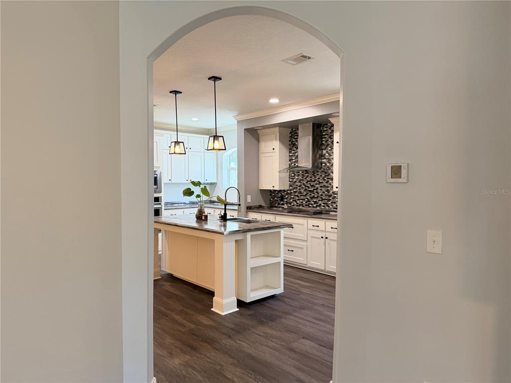 4440 Southwest 63rd Boulevard Gainesville, FL 32608 - Photo 13 of 49 a kitchen with white cabinets and wooden floor
