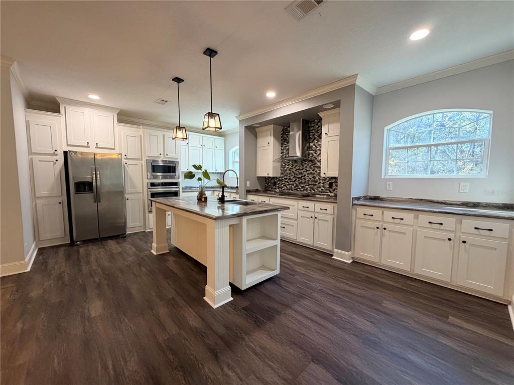 4440 Southwest 63rd Boulevard Gainesville, FL 32608 - Photo 14 of 49 a kitchen with white cabinets and stainless steel appliances