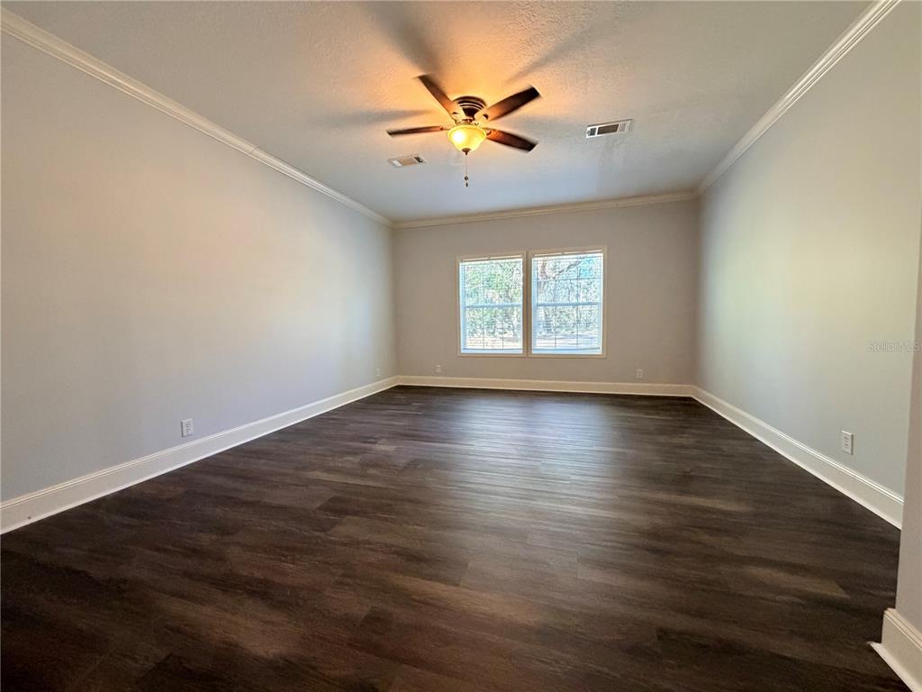 4440 Southwest 63rd Boulevard Gainesville, FL 32608 - Photo 24 of 49 an empty room with wooden floor and windows