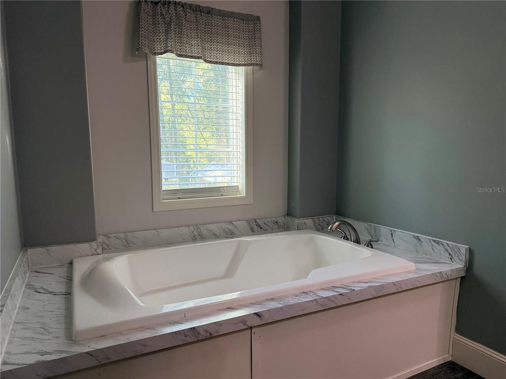 4440 Southwest 63rd Boulevard Gainesville, FL 32608 - Photo 28 of 49 a bathroom with a bathtub and window